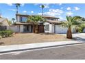 Attractive two-story home with a white facade, dark trim, and desert landscaping at 5035 Meadow Grove Ct, Las Vegas, NV 89120