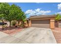 Single-story home featuring a well-maintained yard, mature tree, and a two-car garage at 5588 La Sendas Ct, Las Vegas, NV 89122