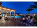 Relaxing backyard with a sparkling pool, cozy fire pit, and comfortable seating area at 5852 Ireland Ridge Ct, Las Vegas, NV 89149