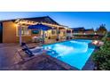 Inviting backyard pool and patio with in-pool seating and lush landscaping at 5852 Ireland Ridge Ct, Las Vegas, NV 89149