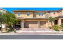 Street view of a two-story home featuring a three-car garage and low maintenance landscaping at 600 Suncrest Peak Pl, Henderson, NV 89011