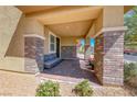 Inviting covered front porch with brick pillars and pavers, perfect for relaxing and enjoying the outdoors at 600 Suncrest Peak Pl, Henderson, NV 89011