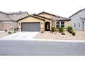 Inviting single-story home featuring low-maintenance landscaping, a gray two-car garage, and a neutral color palette at 645 Turtleback Falls Ave, Indian Springs, NV 89018