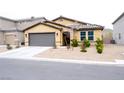 Charming single-story home with a tile roof, gravel yard, and a gray two-car garage at 645 Turtleback Falls Ave, Indian Springs, NV 89018