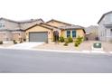 Charming single-story home with a tile roof, gravel yard, and a gray two-car garage at 645 Turtleback Falls Ave, Indian Springs, NV 89018