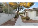 A walkway leads past landscaped areas with rocks, bushes, and a view of the house's exterior at 6733 W Charleston Blvd # 3, Las Vegas, NV 89146