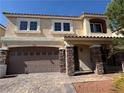 Attractive two-story home featuring a stone accented two-car garage, inviting entryway, and desert landscaping at 6778 Goose Watch Ct, Las Vegas, NV 89139