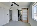 Bright bedroom featuring a sliding barn door leading to an en-suite bathroom at 709 Rossmoyne Ave, North Las Vegas, NV 89030