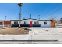 Charming single-story home showcasing a red front door, desert landscaping, and mature palm tree at 709 Rossmoyne Ave, North Las Vegas, NV 89030