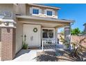 Inviting front porch with seating area, double doors, and desert landscaping, creating a warm welcome at 7360 Dolphine Crest Ave, Las Vegas, NV 89129