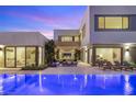 Inviting backyard features a sparkling pool, lounge area, and modern architecture under a beautiful sunset sky at 7385 Heron Canyon Ct, Las Vegas, NV 89117