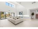 Expansive living room with high ceilings, large windows, and stylish furnishings create a bright and airy atmosphere at 7385 Heron Canyon Ct, Las Vegas, NV 89117