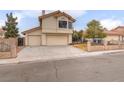 View of a two-story home with a large driveway and desert landscaping at 7445 Shangri La Ave, Las Vegas, NV 89147