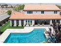 Stunning backyard featuring a pristine blue swimming pool, patio seating, and lush landscaping at 7569 Shadow Estates Way, Las Vegas, NV 89113