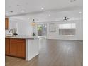 Open living area with wood-look floors, recessed lighting, and sliding glass doors to the backyard at 8043 Texas Hills St, Las Vegas, NV 89113