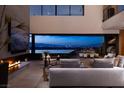 Sophisticated living area with fireplace, expansive windows, and seamless flow to an outdoor entertainment space at 811 Magnum Cliff Ct, Henderson, NV 89012