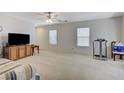 Spacious living room with plush carpeting, natural light, and a media center for entertainment at 8783 Halcon Ave, Las Vegas, NV 89148