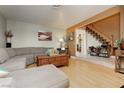 Inviting living room with a comfortable sectional sofa and staircase access at 408 N Torrey Pines Dr, Las Vegas, NV 89107