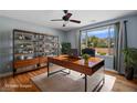 Well-lit office with modern desk, shelving, and views of the landscaped yard at 10281 Wolves Den Ln, Las Vegas, NV 89178
