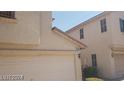 Beige two-story home featuring a two-car garage and desert landscaping at 10282 Keystone Pastures St, Las Vegas, NV 89183