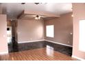 Spacious living room with hardwood floors, a ceiling fan, and a large window at 128 Golf Course St, Las Vegas, NV 89145