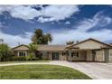 Inviting single-story home with a covered carport, manicured lawn, and circular driveway at 1712 Chapman Dr, Las Vegas, NV 89104