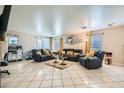 Spacious living room with tile flooring, neutral walls, and comfortable leather seating at 2301 Cambridge Elms St, North Las Vegas, NV 89032