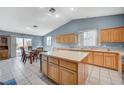 Well-lit kitchen with wood cabinets, large center island, and tiled floor, perfect for cooking and entertaining at 2712 Peekskill Ave, Henderson, NV 89052