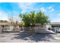 Street view of a well-maintained single-story home featuring a metal fence and mature trees at 2732 Johannson Ln, Las Vegas, NV 89115