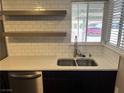 Updated kitchen sink with stainless steel dishwasher, open shelving and subway tile backsplash at 30 Diamond Cir, Las Vegas, NV 89106