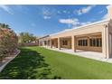 Expansive artificial turf backyard features covered patio perfect for outdoor entertaining at 3032 Bonnie Rock Dr, Las Vegas, NV 89134