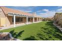 Spacious backyard features lush artificial turf, a covered patio and low-maintenance landscaping at 3032 Bonnie Rock Dr, Las Vegas, NV 89134