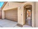 Close-up of beige house featuring a two-car garage and gated front entry at 35 Glade Water Dr, Henderson, NV 89052