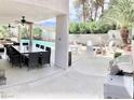 Covered outdoor dining area with a large table, alongside a relaxing outdoor lounge with a firepit near the pool at 3886 Green Leaf Dr, Las Vegas, NV 89120