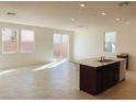 Spacious kitchen featuring a large island, tile floors, white walls and granite countertops at 4274 Tarim St, Las Vegas, NV 89147
