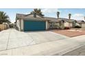 Inviting single-story home with a well-maintained lawn, desert landscaping, and a blue garage door at 4813 Canadian Dr, Las Vegas, NV 89130