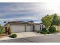 Single-story home featuring a three-car garage, desert landscaping, and a stylish tile roof at 5903 Karnes Ranch Ave, Las Vegas, NV 89131