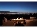 Cozy outdoor seating area featuring a modern fire pit with panoramic views of the city skyline at 661 Dragon Peak Dr, Henderson, NV 89012