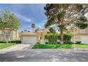 Lovely house showcasing a red tile roof, manicured lawn, mature trees, and an attached two-car garage in a serene neighborhood at 8221 Crow Valley Ln, Las Vegas, NV 89113
