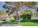 Charming home featuring a well-manicured lawn, mature trees, and a two-car garage at 8221 Crow Valley Ln, Las Vegas, NV 89113