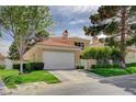 Charming home featuring a well-manicured lawn, mature trees, and a two-car garage at 8221 Crow Valley Ln, Las Vegas, NV 89113