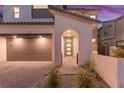 Welcoming front entrance with an arched entry, modern door with wreath, and a two-car garage at 828 Parker Mesa St, Las Vegas, NV 89138