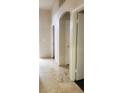 Hallway featuring neutral tile flooring, decorative archway and multiple doorways at 857 Lantham Pl, Las Vegas, NV 89110