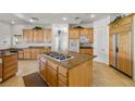 Spacious kitchen featuring light wood cabinetry, granite counters, and a cooktop island at 8838 Spanish Mountain Dr, Las Vegas, NV 89148