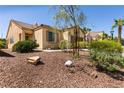 Inviting single-story home with desert landscaping, a two-car garage, and mature trees at 9001 Picket Fence Ave, Las Vegas, NV 89143