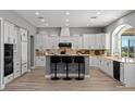 Bright kitchen featuring white cabinetry, an island with bar seating, stainless appliances, and a tile backsplash at 9421 Queen Charlotte Dr, Las Vegas, NV 89145