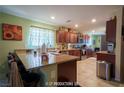 Well-lit, traditional style kitchen with dark wood cabinets, granite countertops, stainless steel appliances, and eat-in bar at 9431 S Tee Pee Ln, Las Vegas, NV 89178