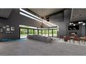 Open-concept living room with floor-to-ceiling windows, gray sectional, modern chandelier, fireplace, and dining area at , Henderson, NV 89012