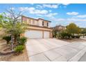 View of the home showcasing its desert landscaping and a spacious two-car garage at 10143 Canyon Hills Ave, Las Vegas, NV 89148