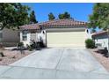 Traditional single-story house showcasing a two-car garage, desert landscaping, and a tile roof at 1121 Majestic Canyon St, Henderson, NV 89052